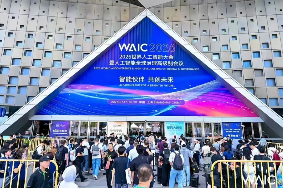 Crowds queue outside the Shanghai World Expo Exhibition and Convention Center beneath the WAIC 2026 entrance display.